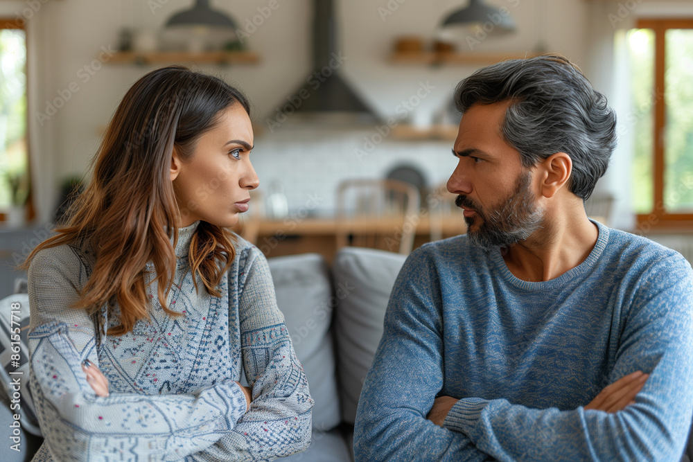 A couple, arms crossed, engaged in a serious argument. Their expressions show frustration and anger, reflecting the strain in their relationship. A couple, arms crossed, engaged in a serious argument. Their expressions show frustration and anger, reflecting the strain in their relationship.