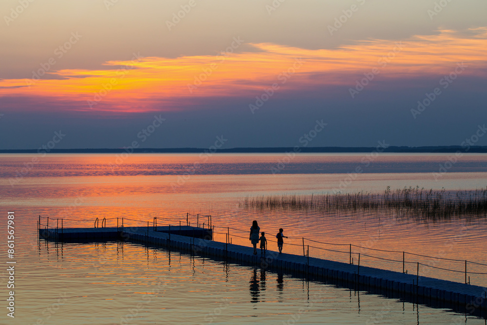 family on pontoon pier at sunset