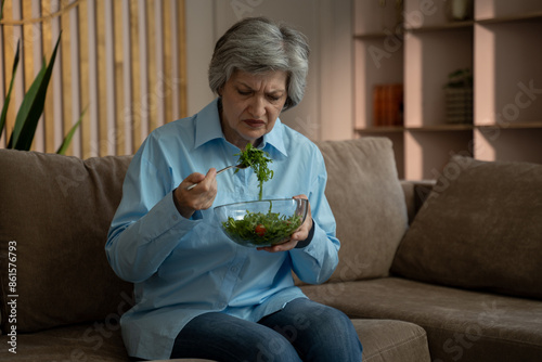 Fotografia An elderly woman is sitting on the couch in the living room