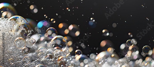 Soap bubbles creating foamy textures against a dark backdrop with abundant copy space image.