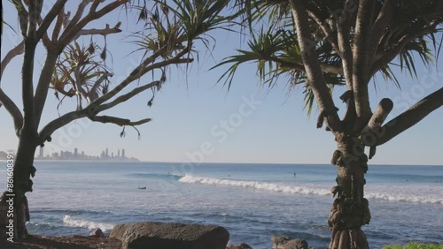 a wide angle shot of a surfer riding a wave on a beautiful sunny winter's afternoon at burleigh heads in queensland, australia photo