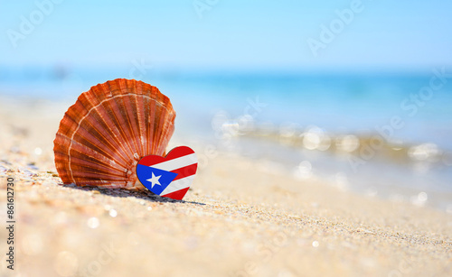 Sandy beach in Puerto Rico. Flag of Puerto Rico in the shape of a heart and a large shell. A wonderful seaside resort.