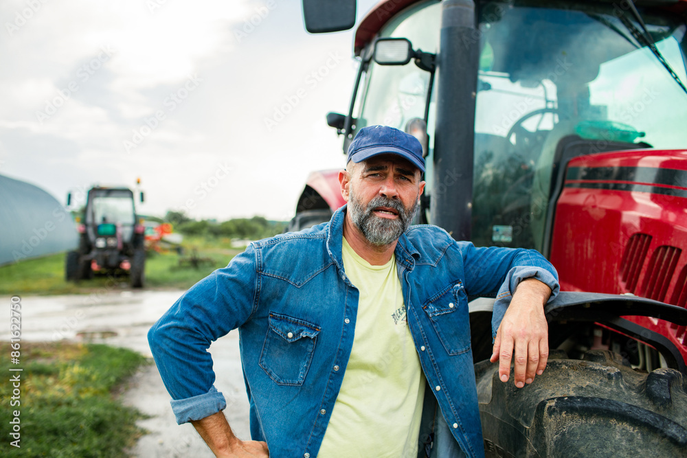 Portrait of a middle aged male farmer on field with tractor
