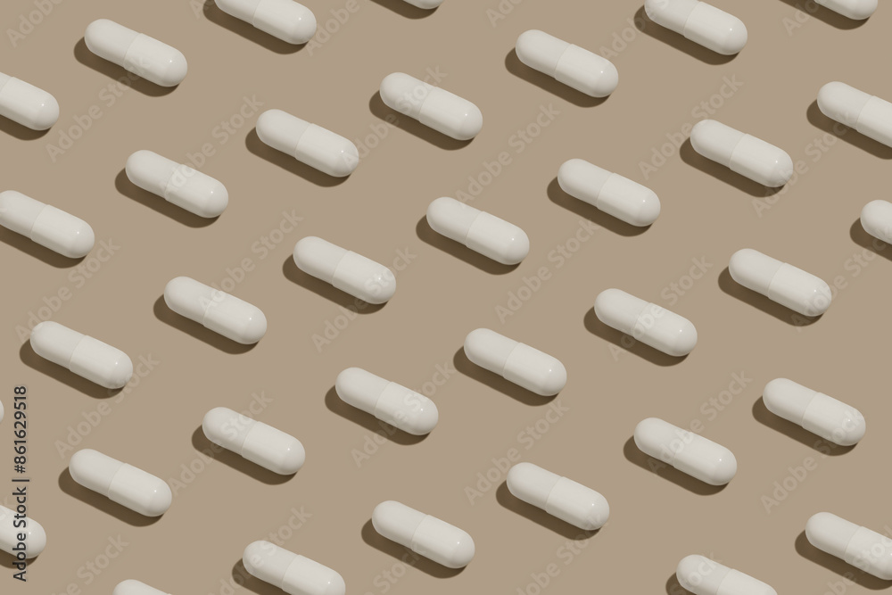 White pills capsules pattern on beige isolated background. Concept of pharmaceuticals, vitamins and health supplements. Image for your design White pills capsules pattern on beige isolated background. Concept of pharmaceuticals, vitamins and health supplements. Image for your design