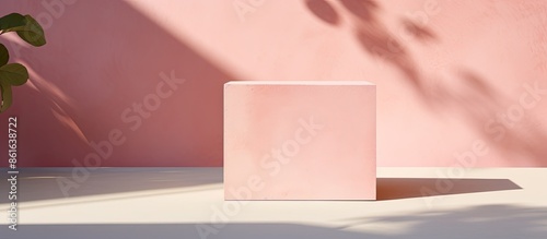 Sunlight illuminates a concrete cube podium with shadow on a pink background, creating a minimalistic abstract shopping sales concept for cosmetic beauty brands products mock up, with copy space photo