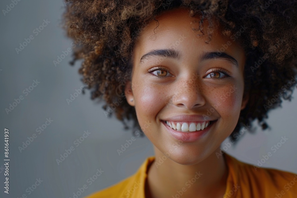 A person with a large afro hairstyle smiling directly at the camera A person with a large afro hairstyle smiling directly at the camera