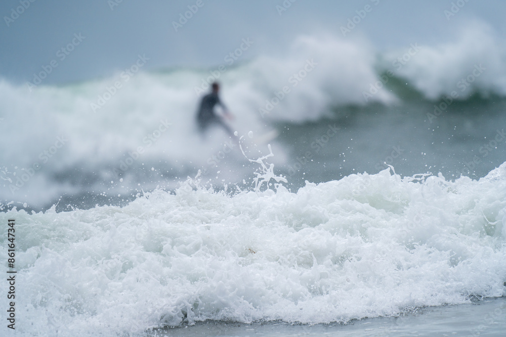 Naklejka premium Surfer in the Mist of Ocean Waves