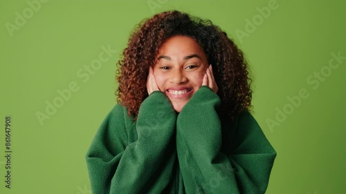 Happy and joyfull surprised woman in cozy sweater on a green screen background, screaming WOW