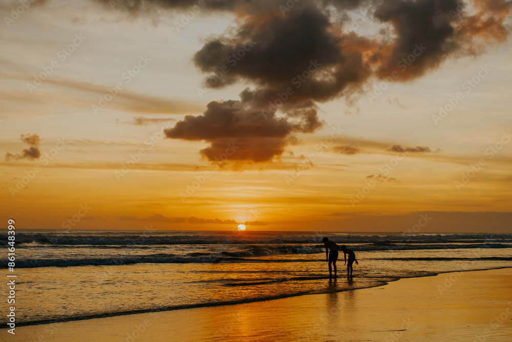 Silhouette of father and son playing on the beach at sunset Silhouette of father and son playing on the beach at sunset