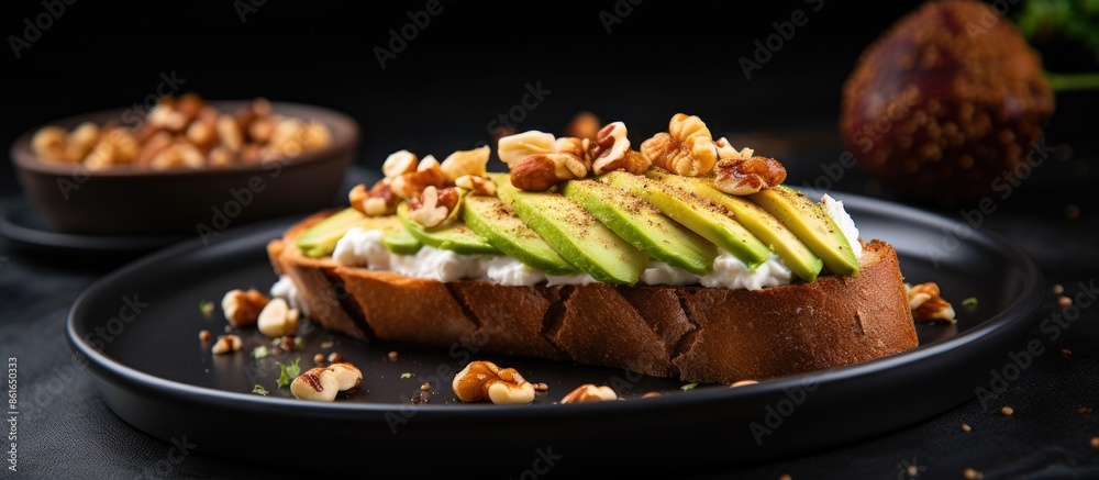 French loaf slices topped with avocado, poached egg, and walnuts on a black lava plate on a wooden table with a warm tone background enhancing the copy space image.