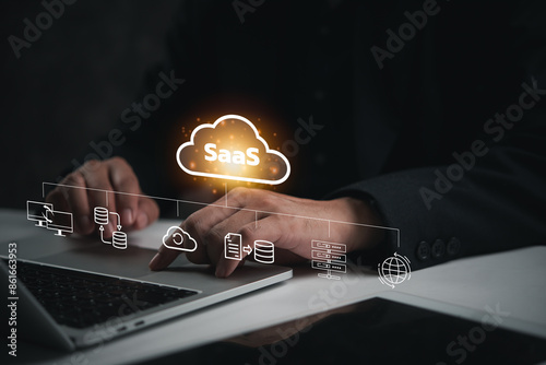 Hand interacting with SaaS icons above laptop, showcasing software as a service concept. Perfect for technology, cloud computing, digital business solutions.