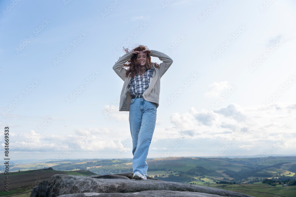Obraz premium Happy Woman With Long Red Hair Posing on Mountain Top