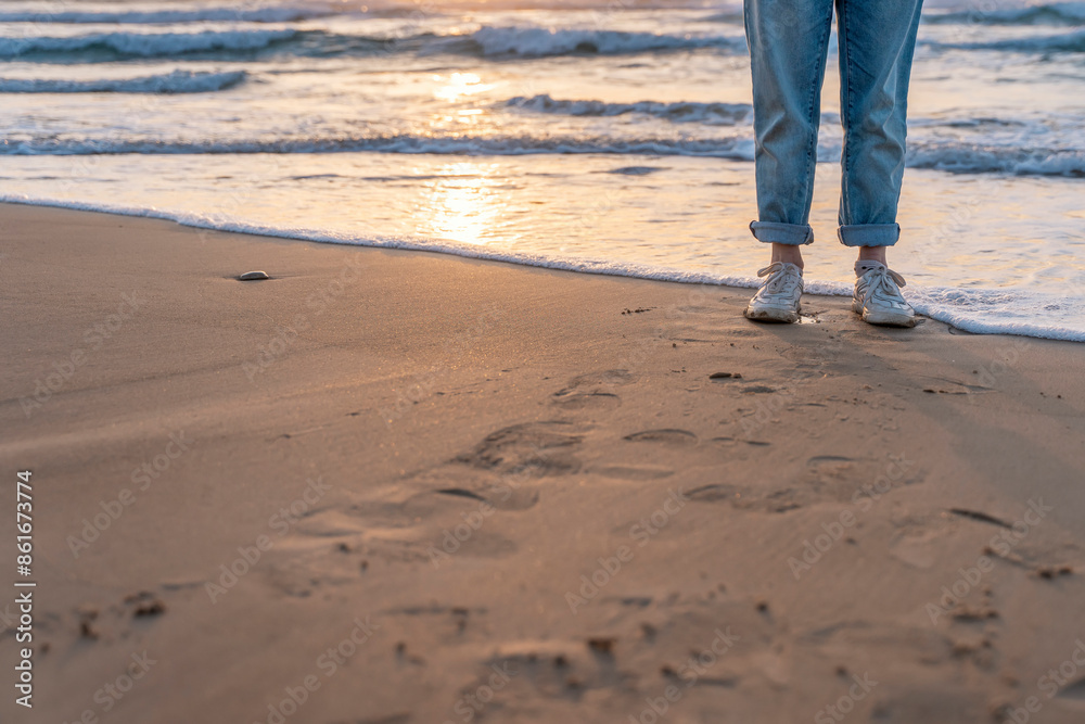 Person Standing on Sandy Beach With Ocean Waves at Sunset Person Standing on Sandy Beach With Ocean Waves at Sunset