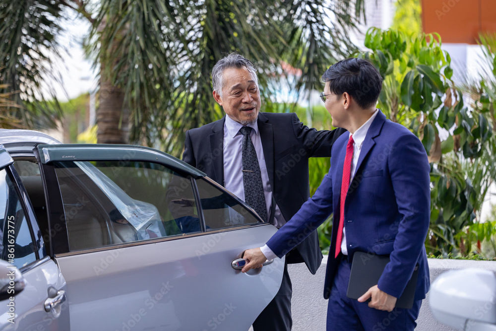 Fototapeta premium Senior executive businessman CEO manager or politician in formal suit is arriving at the office while his secretary is opening the door to welcome him for millionaire and success