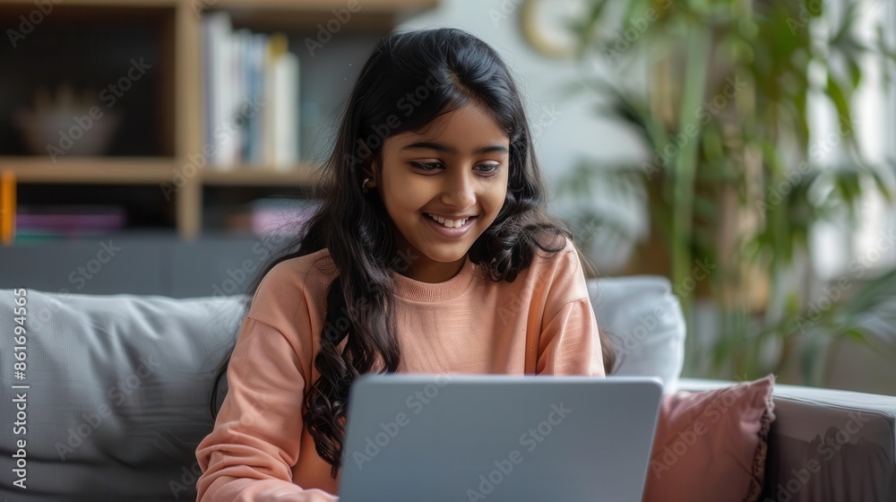 Naklejka premium smiling indian teen girl using laptop for online study happy student in webinar