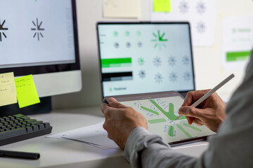 Close-up shot of a graphic designer making notes on logo designs, using a tablet, designing logos, and showcasing the corporate identity and logo design process.