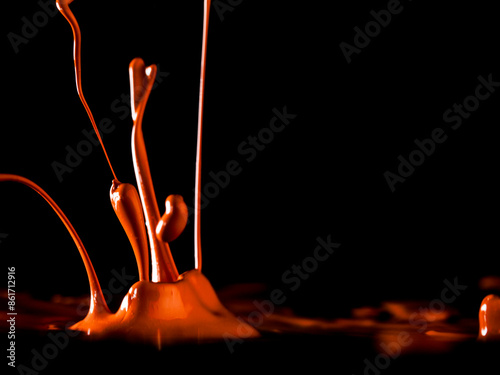 Colorful paint jumping in different forms in front of black background. photo