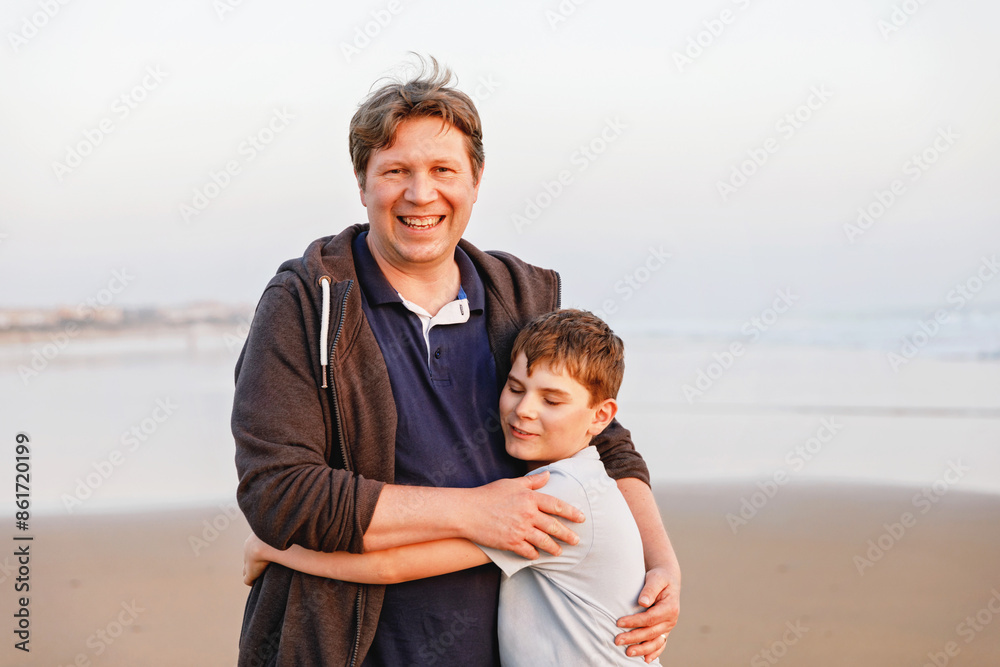 Healthy loving father and son together at the beach at sunset Happy family, love. Preteen boy and middle-aged man hugging. Happy relationship between parents and children. Healthy loving father and son together at the beach at sunset Happy family, love. Preteen boy and middle-aged man hugging. Happy relationship between parents and children.