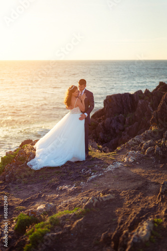 Bride and groom contemplating each other on a cliff
