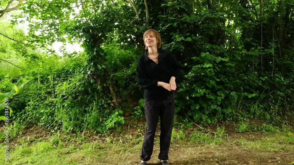 A woman dances alone in a beautiful green forest A woman dances alone in a beautiful green forest