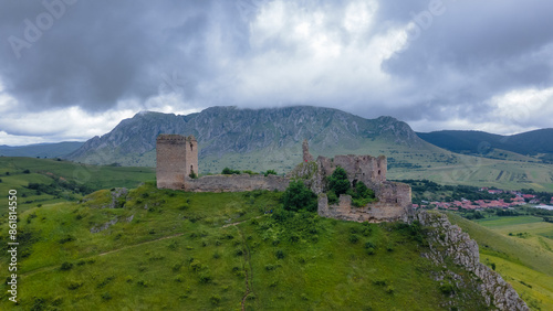Aerial photo of the ruins of Trascau medieval citadell in Romania. Photography was shoot from a drone with camera level for a panoramic view of the fortification with the mountains in the background.