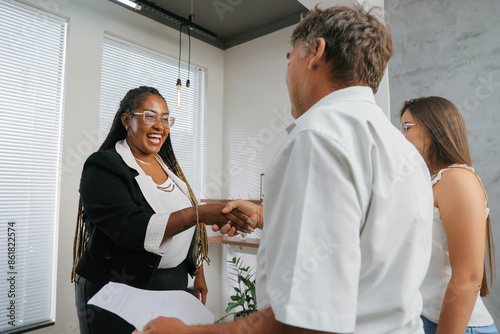 Successful black businesswoman shaking hands with her client during meeting.