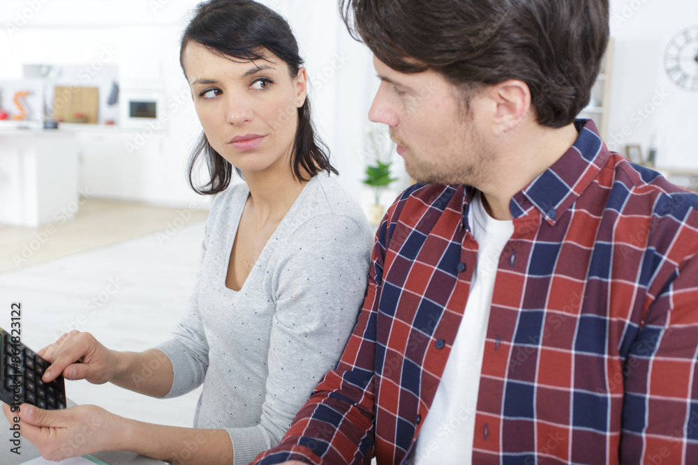 serious couple with calculator doing their accounts serious couple with calculator doing their accounts