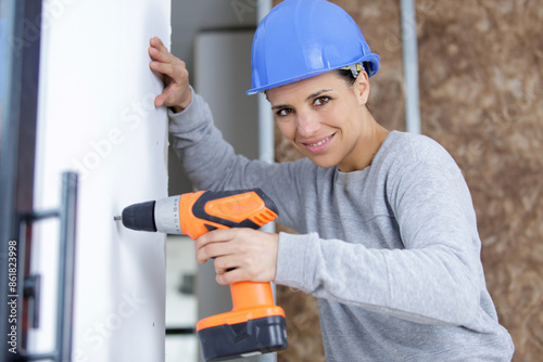 caucasian woman as worker wearing blue protective helmet