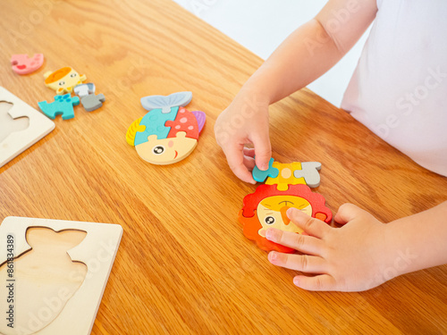 Colorful wooden animal jigsaw puzzles for children to use as toys. It is being built or played with by children placed on a wooden table to build skills and development.