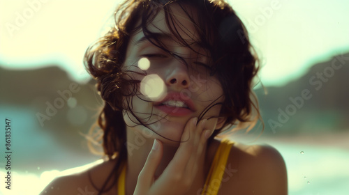 cinematic close-up of a young woman on the dreamy, ethereal beach, with short, curly hair wet and messy, with her eyes half-closed, with bright, natural lighting and bokeh effects photo