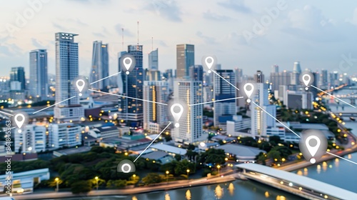 An aerial view of a modern city at dusk, with white location pin icons interconnected by lines, representing the interconnectedness of a global network photo