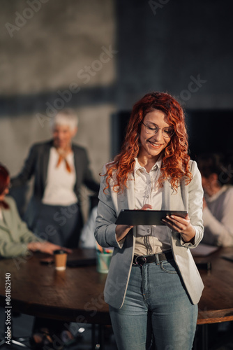 Smiling saleswoman analyzing market on tablet at office on meeting. © Zamrznuti tonovi