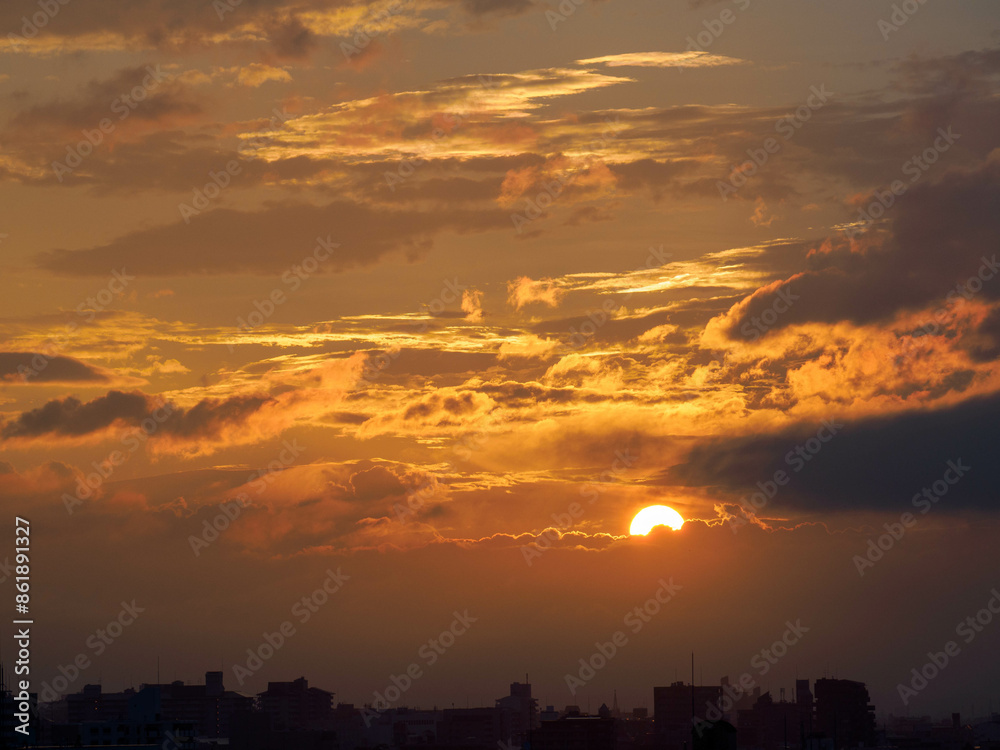 Fototapeta premium 都市の夜明け。雲の隙間から太陽が顔を出す