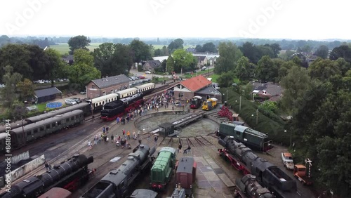 Beekbergen, the Netherlands - August 6th, 2023: Ascending drone footage of people lining up to see a steam locomotive on the local marshalling yard before it leaves on a trip to nearby Dieren. photo