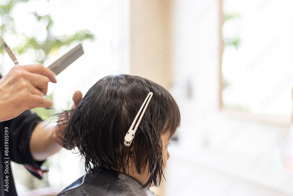 Naklejka premium 美容院でヘアカットする女の子の後ろ姿（3歳、日本人、ショートヘア）