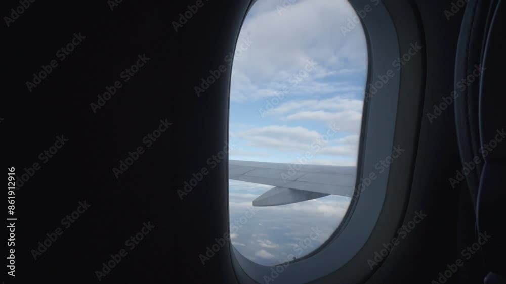 A view of the sky from an airplane window. The sky is mostly blue with some clouds scattered throughout A view of the sky from an airplane window. The sky is mostly blue with some clouds scattered throughout