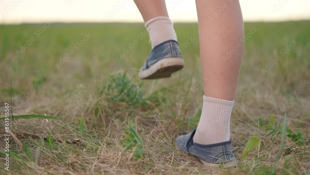 A child is running on his legs through the grass. Run field race concept. A kid is running in a park with his legs down. A kid running on his legs in the grass in a lifestyle park. A child is running on his legs through the grass. Run field race concept. A kid is running in a park with his legs down. A kid running on his legs in the grass in a lifestyle park.