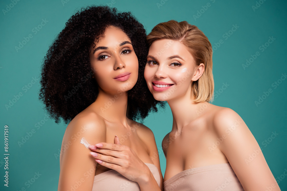 Photo of attractive girls touch hands shoulder using cream on skin isolated cyan color background Photo of attractive girls touch hands shoulder using cream on skin isolated cyan color background
