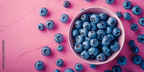Fresh Blueberries in Bowl on Vibrant Pink Background photo