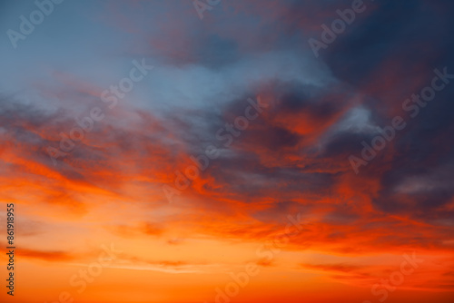  Scenic sunset with clouds in a colorful sky. Beautiful orange and blue sky with clouds. Heaven is filled with clouds and the sun is setting © russieseo
