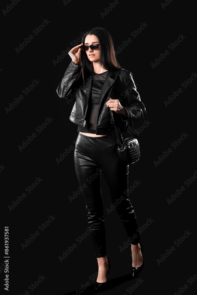 Beautiful stylish young woman in leather jacket on black background Beautiful stylish young woman in leather jacket on black background