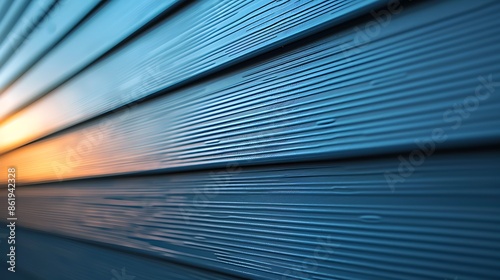 close-up of vinyl siding in a cool steel blue, with the light of a winter sunset casting a warm glow on its surface