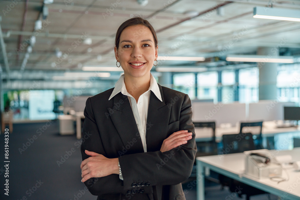 A confident businesswoman is standing and posing in a modern office environment A confident businesswoman is standing and posing in a modern office environment