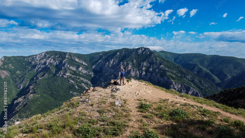 Fototapeta premium Man on Edge of Peak Summer Hiking views in the Mountains of Snowbasin Huntsville Utah 