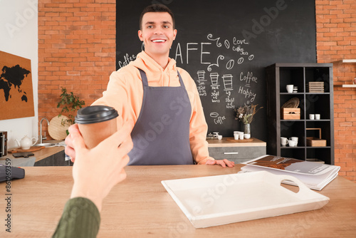 Male barista giving coffee ...
