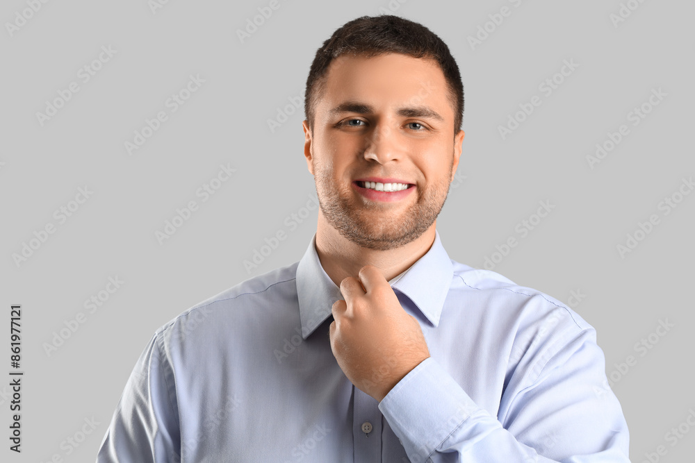 Handsome businessman smiling on grey background, closeup Handsome businessman smiling on grey background, closeup