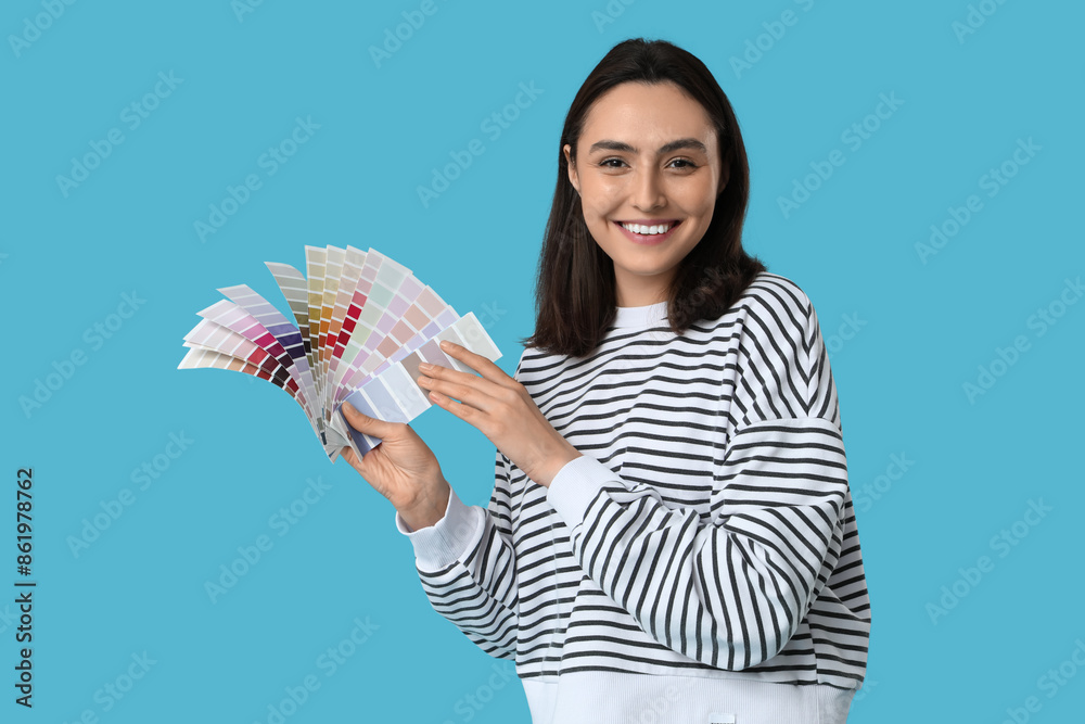 Young woman with color palettes on blue background Young woman with color palettes on blue background