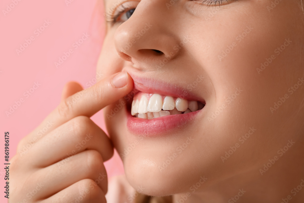 Teenage girl showing her teeth on pink background, closeup Teenage girl showing her teeth on pink background, closeup