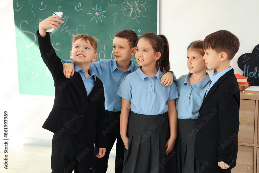 Cute little pupils taking selfie in classroom. School holidays concept Cute little pupils taking selfie in classroom. School holidays concept