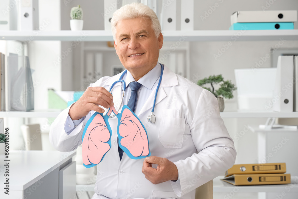 Mature doctor with paper lungs in clinic Mature doctor with paper lungs in clinic